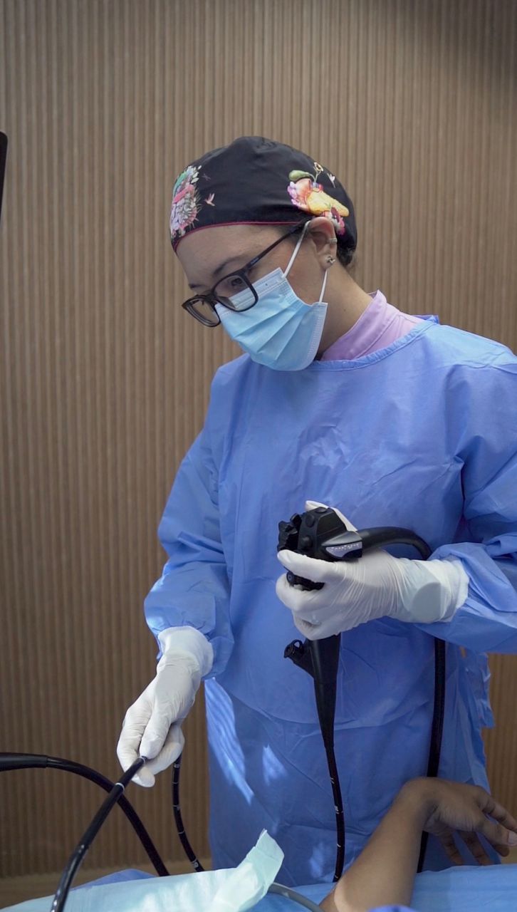 La Dra. Lozada con bata quirúrgica sostiene el endoscopio antes del estudio